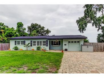 Charming single-story home with a well-manicured lawn, brick driveway, and light blue exterior at 2192 Robinson Dr, St Petersburg, FL 33710