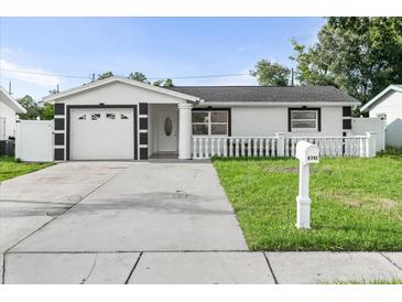 Charming single-story home featuring a manicured lawn and a white picket fence for added curb appeal at 4741 76Th N Ave, Pinellas Park, FL 33781
