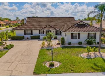 Beautiful single-story home featuring a well-manicured lawn and tile roof at 702 Plumbrook Rd, Sun City Center, FL 33573