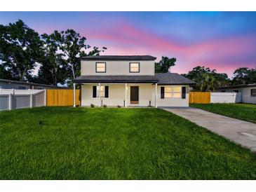 Charming two-story home with a well-maintained lawn and inviting front porch at 7806 N Matanzas Ave, Tampa, FL 33614