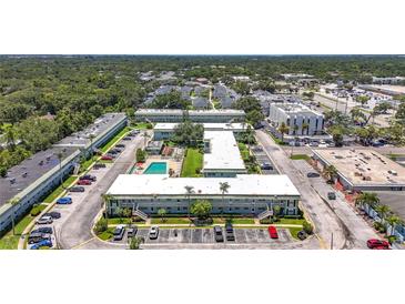 Wonderful aerial view of complex with a swimming pool and well manicured landscaping at 1433 S Belcher Rd # B11, Clearwater, FL 33764