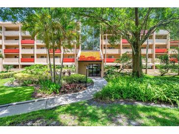Attractive condo complex with well-maintained landscaping and trees leading to the entrance at 3062 Eastland Blvd # 311, Clearwater, FL 33761