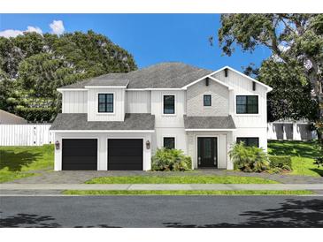 Charming two-story home featuring a modern design with stone accents, black trim, and an attached two-car garage at 4111 W Mullen Ave, Tampa, FL 33609