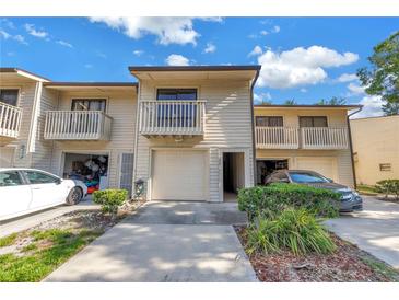 Beige townhome featuring a balcony, garage and well-maintained landscaping, creating an inviting curb appeal at 6236 93Rd N Ter # 3502, Pinellas Park, FL 33782