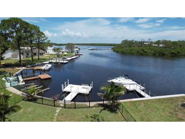 Aerial view of waterfront property featuring boat docks, lush landscaping and access to tranquil waters at 6711 Arroyo Dr, New Port Richey, FL 34652