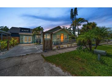 Charming bungalow home featuring lush landscaping, quaint fencing, and a welcoming walkway to the main entrance at 1801 52Nd S St, Gulfport, FL 33707