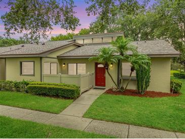 Charming single-story home with vibrant landscaping and a welcoming red front door at 200 Gretchen Ct, Oldsmar, FL 34677