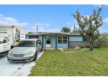 Charming single-story home featuring a well-manicured lawn and a welcoming front porch area at 2149 Dixie Garden Loop, Holiday, FL 34690
