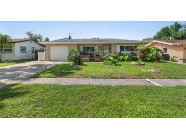 Charming single-story home featuring a well-manicured lawn and lush landscaping at 2518 Keen Park Dr, Largo, FL 33771