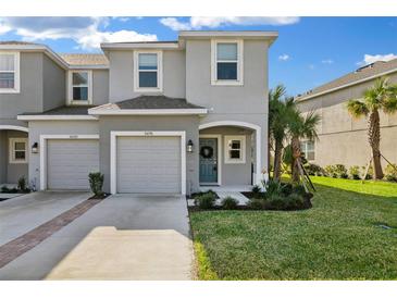 Charming two-story townhouse with a well-manicured lawn and beautiful landscaping at 34196 Polacca Ln, Wesley Chapel, FL 33543