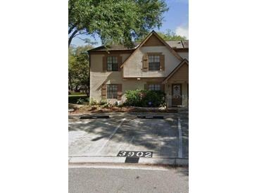Charming two-story condo featuring neutral stucco, shuttered windows and reserved parking at 3902 Brigadoon Cir, Clearwater, FL 33759