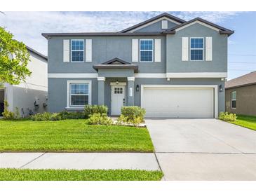 Charming two-story home featuring a well-maintained lawn, attached two-car garage, and welcoming front entrance at 10270 Shady Preserve Dr, Riverview, FL 33578