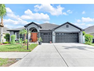 Charming one-story home with a well-manicured lawn, vibrant landscaping, and a spacious two-car garage at 10813 Rockledge View Dr., Riverview, FL 33579
