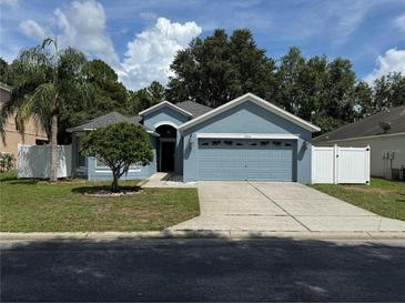 Charming single-story home with a well-manicured lawn and attached two-car garage at 12216 Southbridge Ter, Hudson, FL 34669