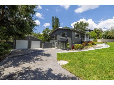 Two-story home boasts a well-kept lawn, a separate garage, and a driveway leading to the entrance at 1600 Lonesome Pine Ln, Tarpon Springs, FL 34689