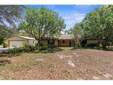 Charming single-story home with a stone accent wall and mature trees, offering privacy and curb appeal at 17207 Bosley Dr, Spring Hill, FL 34610