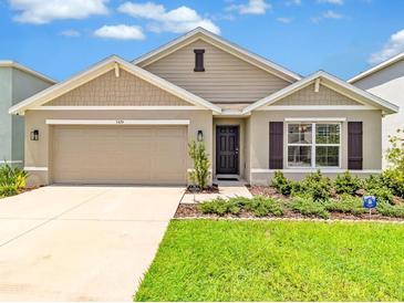 Charming single-Gathering home with a manicured lawn, two-car garage, and neutral color palette at 5474 Flint Hills Dr, Wimauma, FL 33598