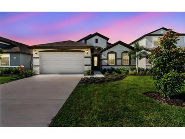 Charming single-Gathering home featuring a two-car garage, well-manicured lawn, and inviting curb appeal at 8077 Tea Olive Ter, Palmetto, FL 34221