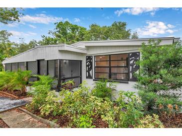 Charming home exterior with lush landscaping and unique window details at 209 Se Jefferson N Cir, St Petersburg, FL 33702