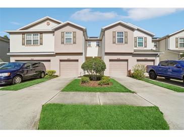 Well-maintained townhomes with a landscaped yard and individual driveways at 4935 White Sanderling Ct, Tampa, FL 33619