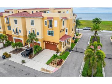 Beautiful yellow townhouses feature red tile roofs and meticulously maintained landscaping at 6412 Mayra Shores Ln, Apollo Beach, FL 33572