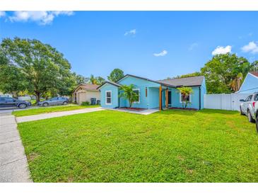 Charming single-story home with a bright blue exterior and lush green lawn at 12351 Cloverstone Dr, Tampa, FL 33624