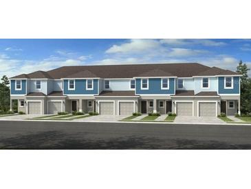 Modern townhome exterior featuring a blue and white facade, garage, and neatly maintained landscaping at 13240 Stable Pl, Parrish, FL 34219