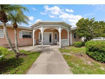 Charming home entrance featuring a decorative white portico, walkway, and a well-maintained lawn at 1453 Belleair Rd, Clearwater, FL 33756