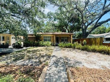 Charming single-story home featuring brickwork and mature trees in a well-maintained front yard at 5901 N 34Th St, Tampa, FL 33610