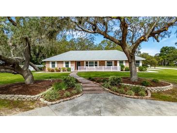 Beautiful brick home with manicured landscaping, brick walkway and a charming white picket fence at 11301 Donneymoor Dr, Riverview, FL 33569