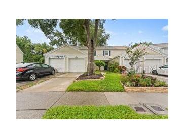 Charming townhome with a well-manicured lawn, front garden bed, and a private driveway at 12336 Villager Ct, Tampa, FL 33625