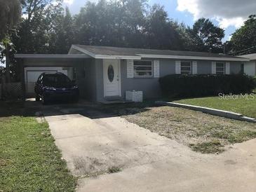 Charming single-story home featuring a carport, well-maintained lawn, and neutral gray paint at 4209 E Hanna Ave, Tampa, FL 33610