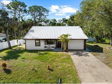 Charming single-story home with a metal roof, fresh white siding, and attached two-car garage at 116 Hermes Rd, Venice, FL 34293