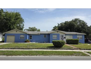 Charming single-story home with a blue facade, well-maintained lawn, and attached garage at 2612 E 17Th Ave, Tampa, FL 33605