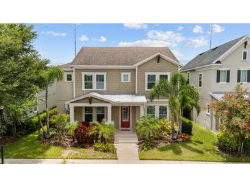 Charming two-story home featuring well-maintained landscaping and a welcoming red front door at 5955 Caldera Ridge Dr, Lithia, FL 33547