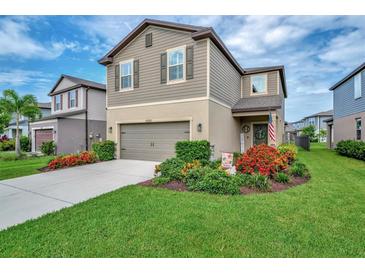 Charming two-story home with well-manicured lawn and colorful flower beds at 6555 Kenava Loop, Palmetto, FL 34221