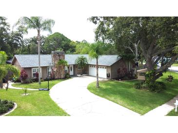 Charming single Gathering home with a well-manicured lawn and inviting curb appeal in a quiet neighborhood at 713 Rustic Oaks Dr, Palm Harbor, FL 34684