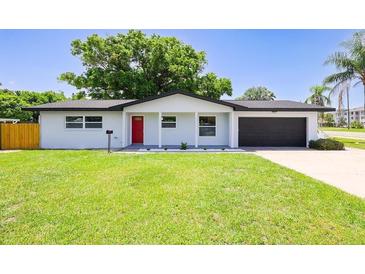 Charming single-story home featuring a red front door, well-manicured lawn, and an attached garage at 800 S Belcher Rd, Clearwater, FL 33764