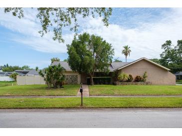 Charming single-story home with stucco exterior, stone accents, mature landscaping, and a lush green lawn at 2421 Eagle Chase Dr, Palm Harbor, FL 34683