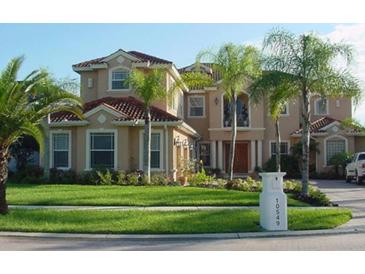 Stately two-story home with a red tile roof, lush lawn, and manicured landscaping at 10549 Cory Lake Dr, Tampa, FL 33647