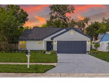 Charming single-story home with a well-manicured lawn and a two-car garage at sunset at 2908 Longbrooke Way, Clearwater, FL 33760