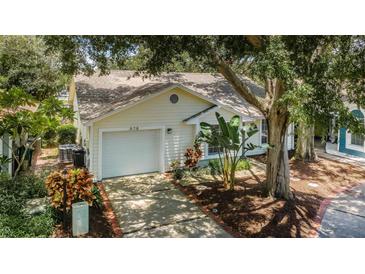 Charming single-story home with a one-car garage and a well-maintained, tree-lined yard and brick-lined driveway at 878 Franklin Cir, Palm Harbor, FL 34683