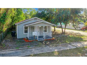 Charming cottage-style home featuring a cozy front porch and fresh landscaping at 2101 E Ellicott St, Tampa, FL 33610
