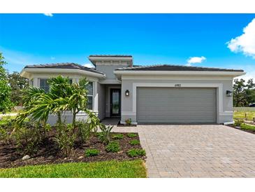 Charming single-story home featuring a two-car garage, paved driveway, and professionally landscaped front yard at 6982 Minneola Ct, Nokomis, FL 34275