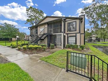 Two-story condo building with mature landscaping and visible stairs at 3964 Dream Oak Pl # 203, Tampa, FL 33613