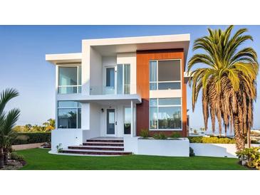 Stunning modern home with a combination of white, wood grain, and glass elements, and a well-manicured front yard at 2608 N Ridgewood Ave, Tampa, FL 33602