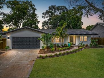 Updated single story home with dark gray garage door and landscaped yard at 2441 69Th S Ave, St Petersburg, FL 33712