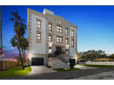 An elegant exterior view of a multi-story home, featuring dual garages and a meticulously landscaped front yard at 3087, 3075 Cherry Ln, Clearwater, FL 33759