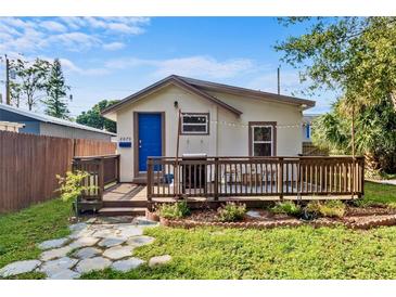 Charming single-story home with a cozy front porch, flower garden and blue front door at 2070 29Th N Ave, St Petersburg, FL 33713