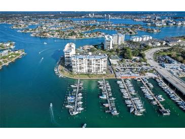 Aerial view of waterfront property with a marina and many boats at 9495 Blind Pass Rd # 307, St Pete Beach, FL 33706